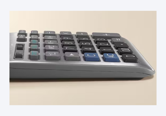 Side view of a grey desktop calculator featuring rounded edges and a mix of black, blue, and grey plastic keys.