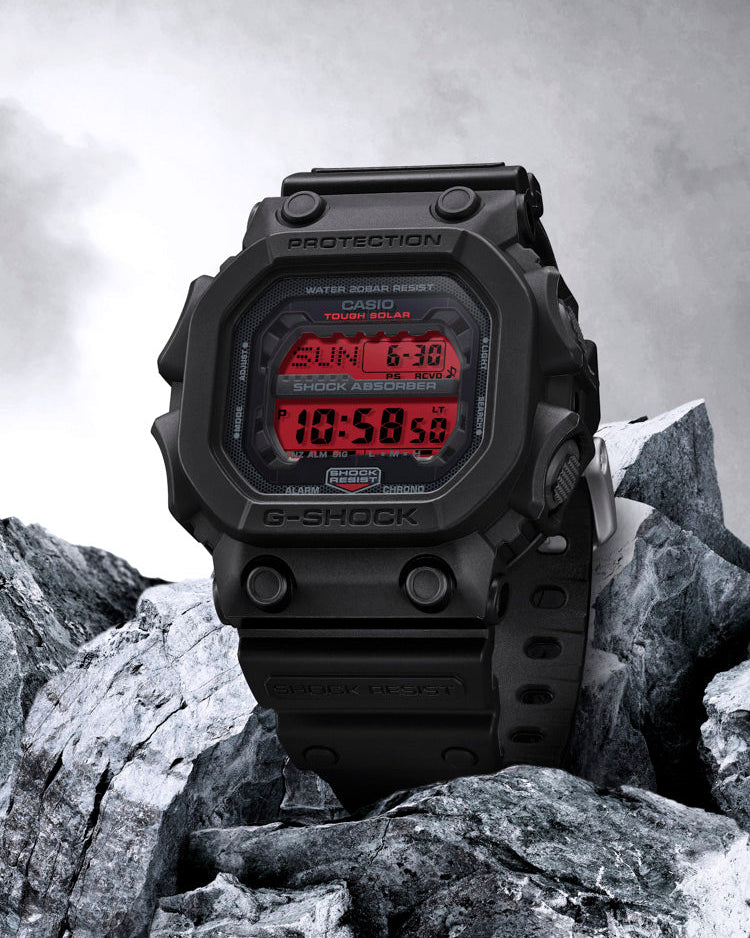 Digital watch with red display on rocky terrain