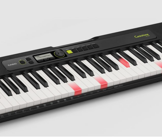 Black Casio Casiotone keyboard with a digital display and keys illuminated by red lights on a light gray background.
