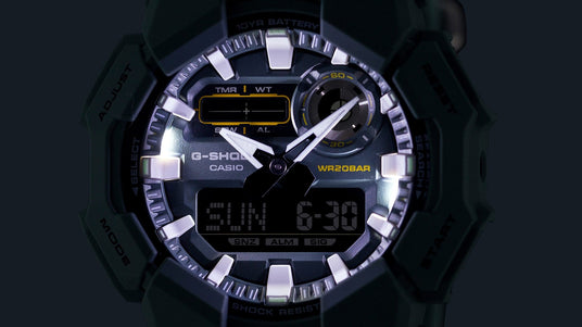 Close-up of a black G-Shock watch face with white hands, yellow accents, and a digital display showing the date.