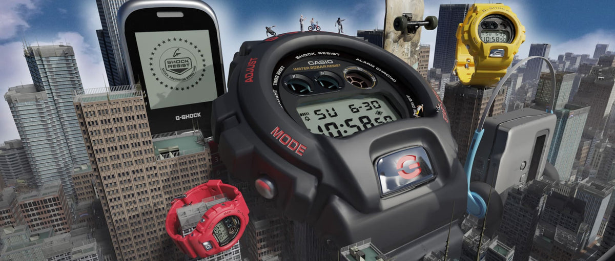 Giant black Casio G-Shock watch floating over a city skyline with smaller red and yellow watches and a digital display.