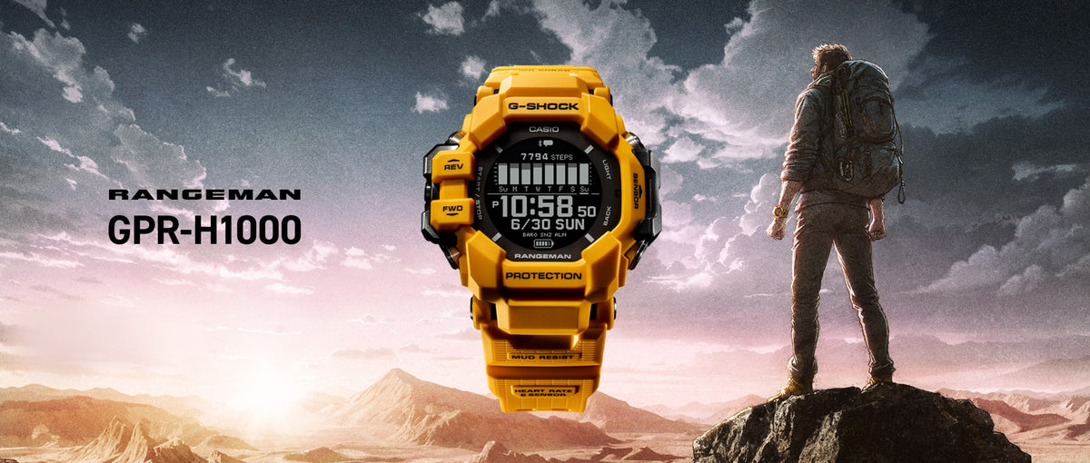 Bright yellow G-SHOCK Rangeman GPR-H1000 watch centered against a hiker overlooking a rugged mountain landscape.