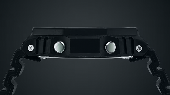 Side profile of a matte black digital watch featuring metallic silver side buttons and a textured resin strap.