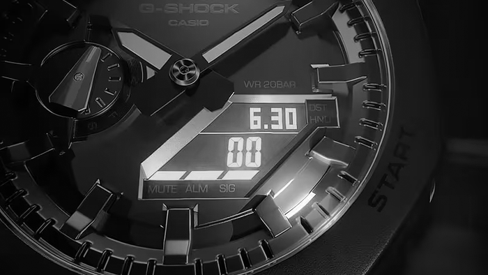 Close-up of a black Casio G-Shock watch face featuring an analog-digital display and metallic indices.