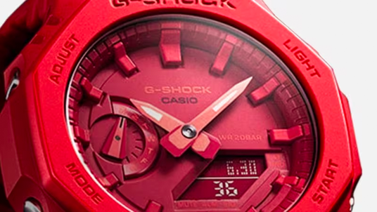 Close-up of a vibrant red Casio G-Shock watch featuring an octagonal bezel, analog hands, and a digital display.