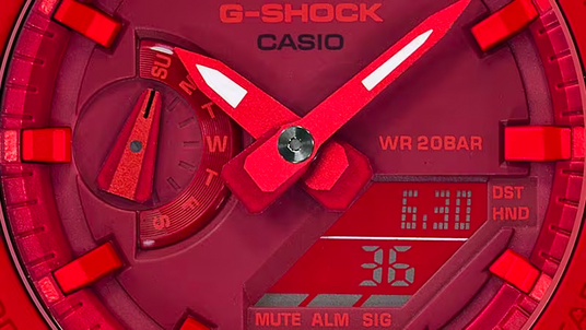 Close-up of a vibrant red Casio G-Shock watch face featuring analog hands, a day indicator, and a digital display.