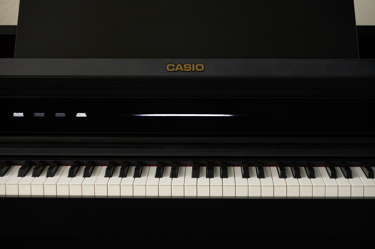 Black Casio Celviano AP-750 digital piano keyboard with illuminated control panel and gold logo.