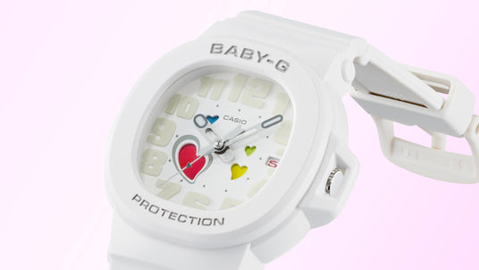 White Casio Baby-G watch with a matte finish, featuring a dial decorated with colorful heart icons and large numerals.