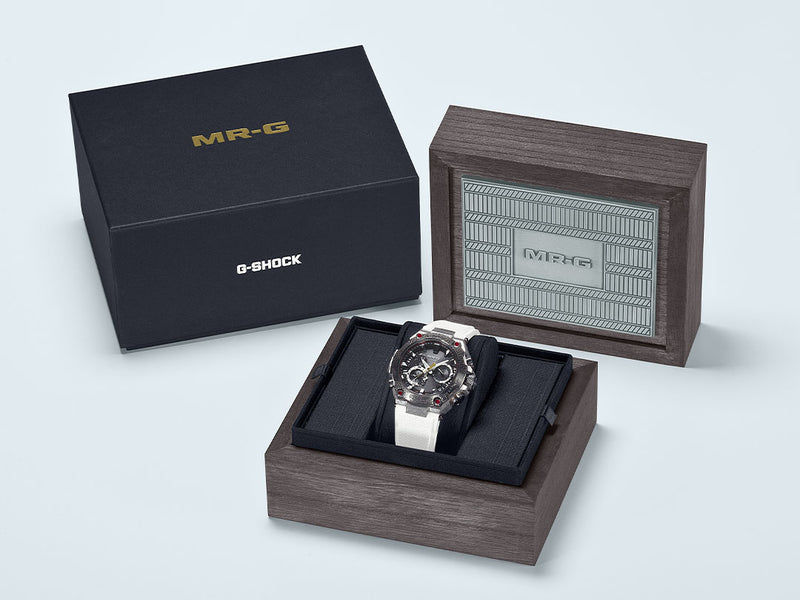 G-Shock MR-G watch with a white strap displayed in a premium wooden presentation box with a black outer case.