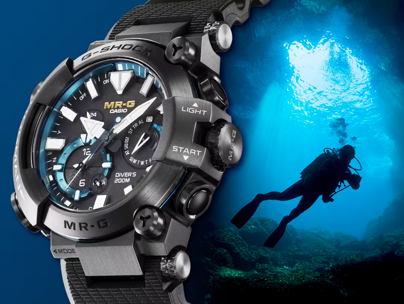 Casio G-Shock MR-G Frogman watch with a black titanium case, blue accents, and a textured strap against a diver background.