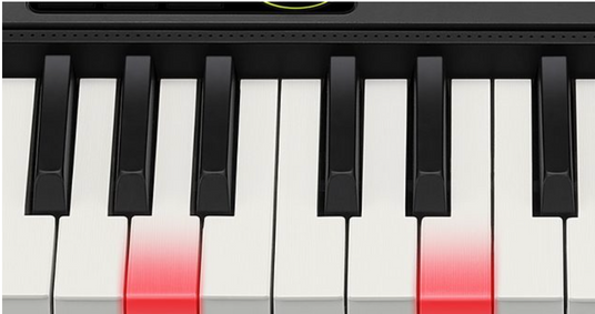 Close-up of a digital keyboard with white and black keys featuring glowing red lights on specific notes.