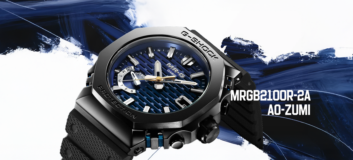 Casio G-SHOCK MRGB2100R-2A Ao-Zumi watch with a black octagonal bezel and textured blue dial against a blue brushstroke.