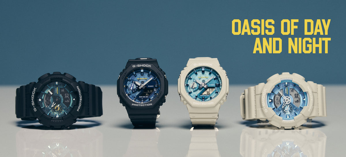Four G-Shock watches in black and beige with blue patterned dials arranged on a reflective surface.