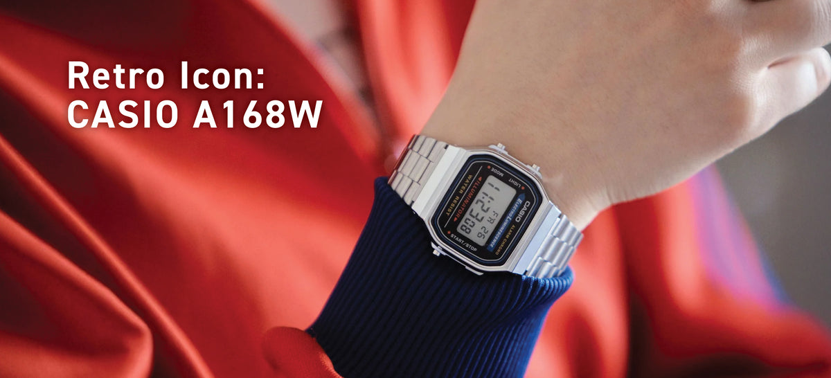 Classic silver Casio A168W digital watch with a metal link strap worn on a wrist against a red jacket.