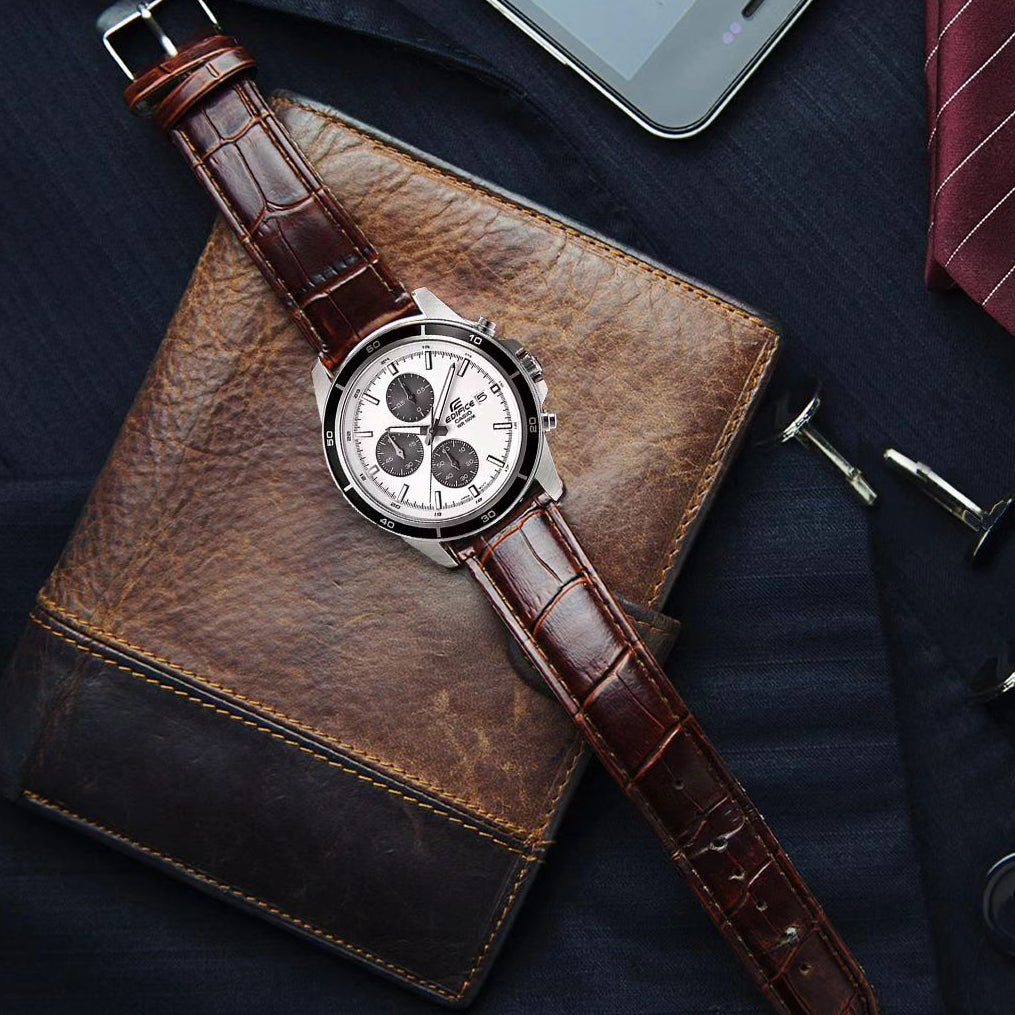Edifice watch with brown leather strap on a dark surface with smartphone and tie