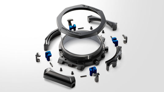 Exploded view of a G-Shock watch showing black metal casing components and small blue accent pieces on a white background.