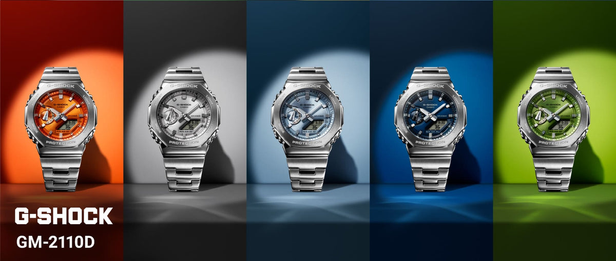 Five G-Shock GM-2110D watches with stainless steel bands and colorful metallic dials against matching backlit backgrounds.