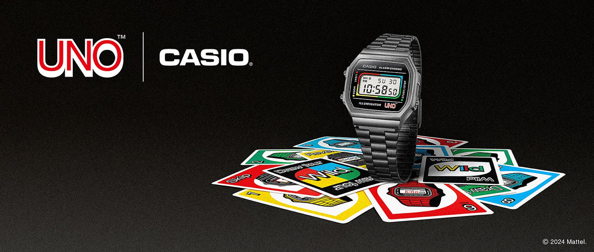 Casio digital watch with a colorful Uno-themed display resting on a pile of scattered Uno playing cards.