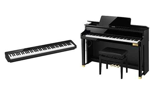A slim black digital keyboard next to a full-size upright digital piano with a matching bench on a white background.